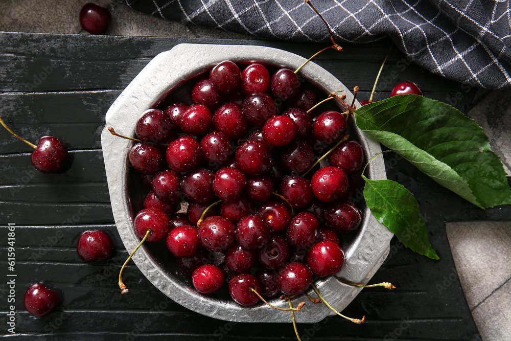 Board with metal plate of sweet cherries, closeup