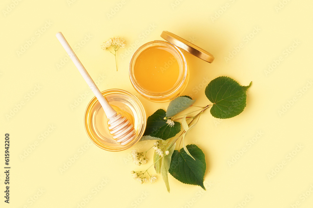 Jar and glass bowl with linden honey on yellow background