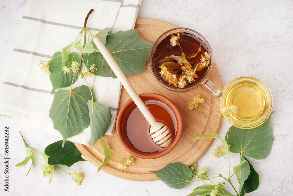 Bowl with linden honey and glass cup of tea on white background