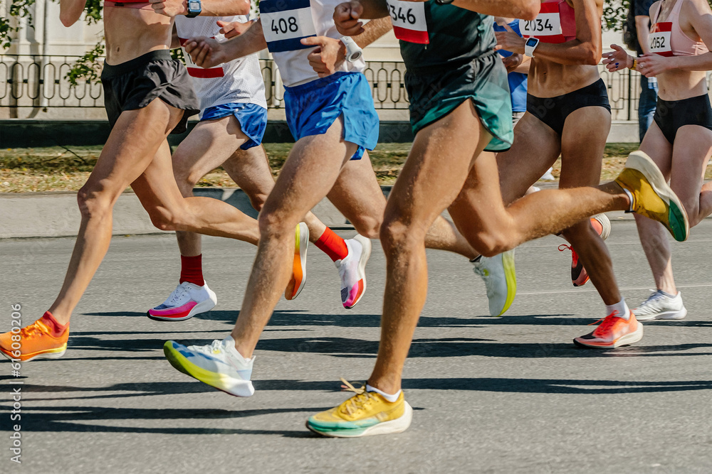 legs runners athletes women and men running city marathon, group sportive joggers run together