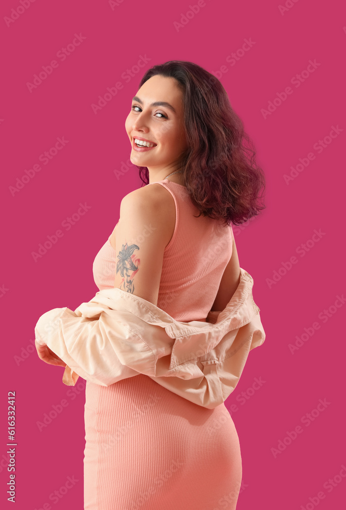 Attractive young woman in dress on pink background