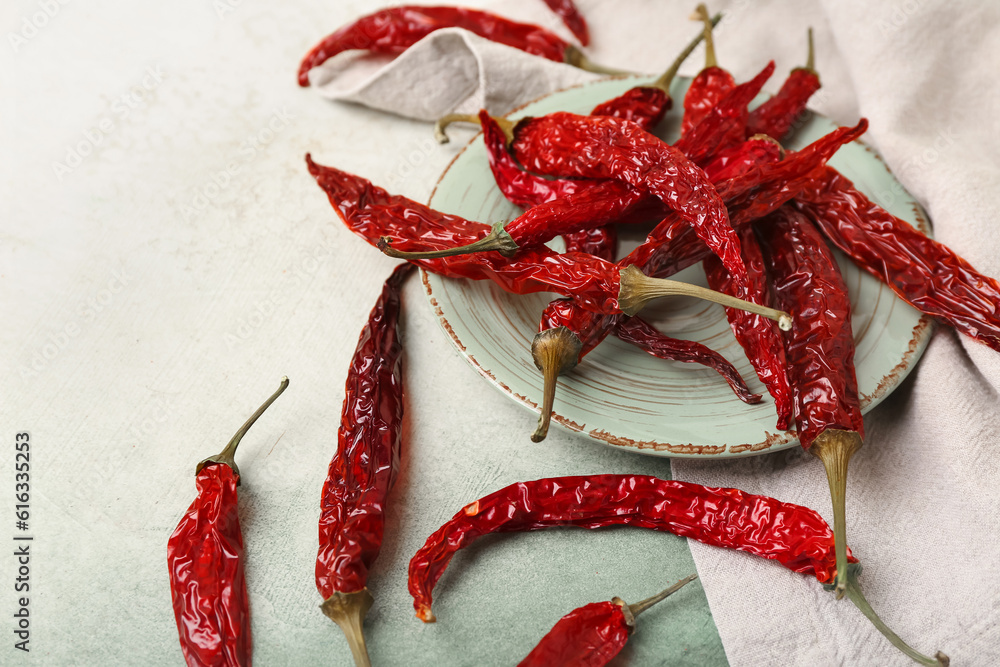 Plate of dry hot chili peppers on light background