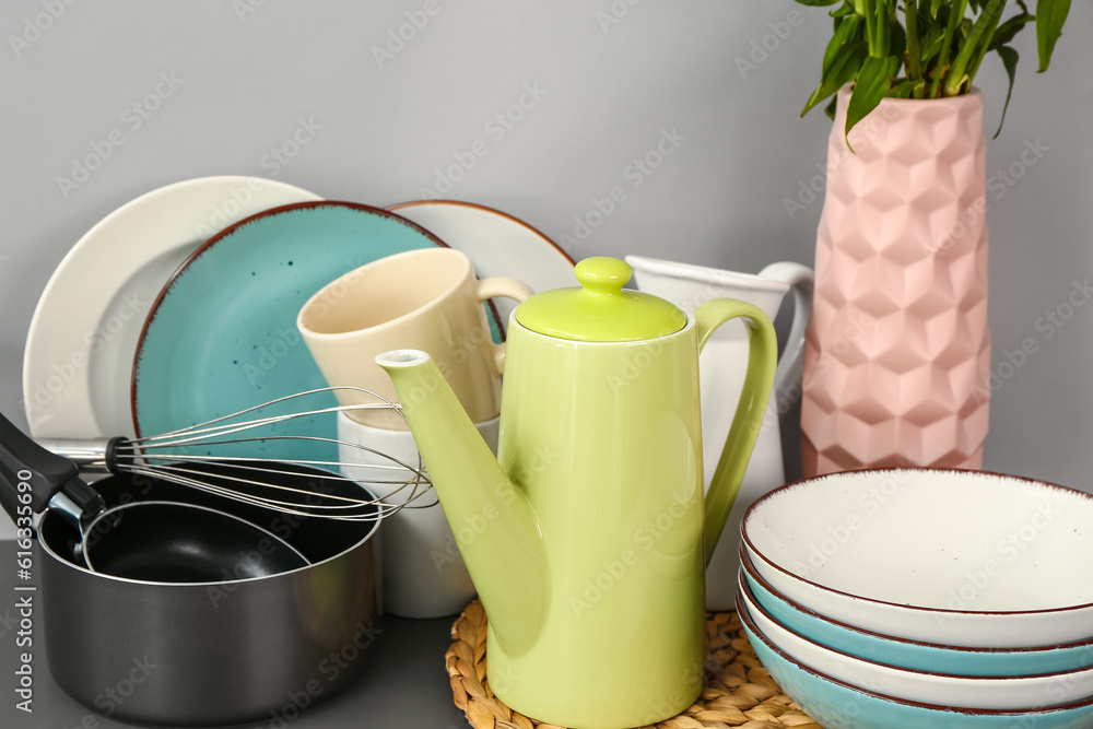 Composition with teapot and different kitchen stuff on black table