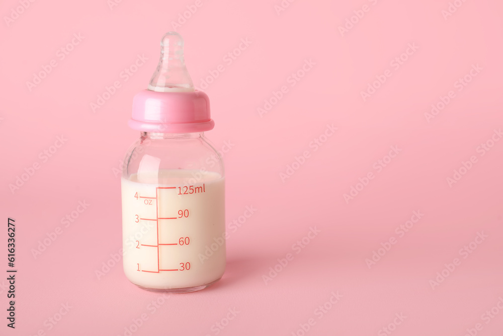 Bottle of milk for baby on pink background