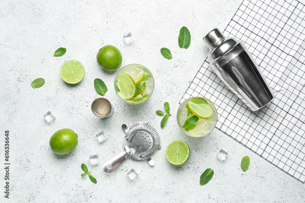 Glasses of tasty mojito and ingredients on light background