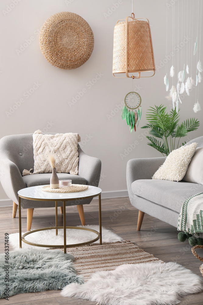 Interior of modern living room with sofa, armchair and dream catcher hanging from lamp