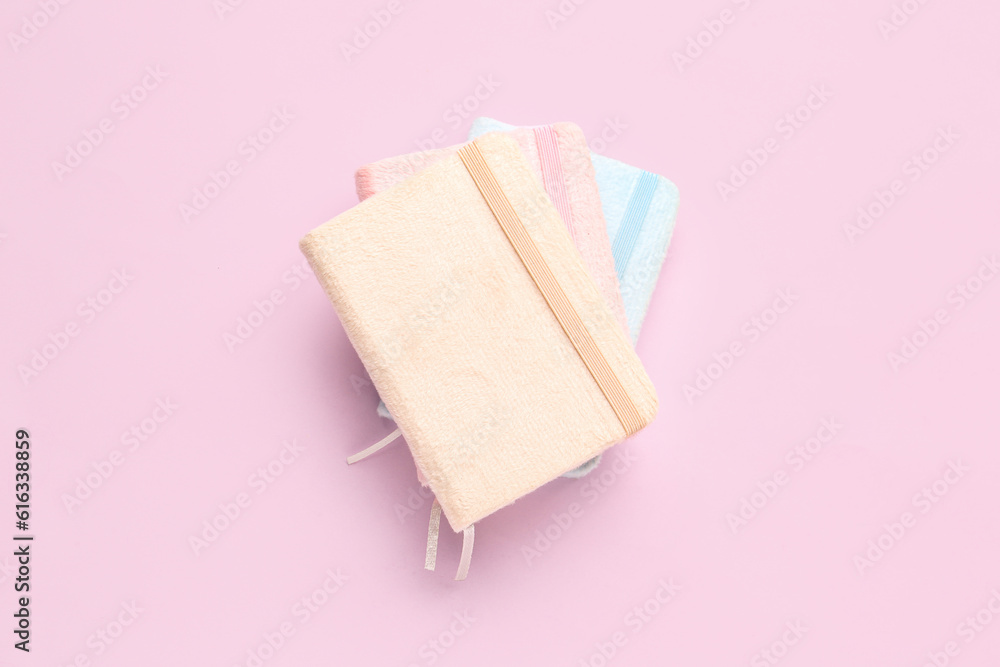 Stack of notebooks on pink background