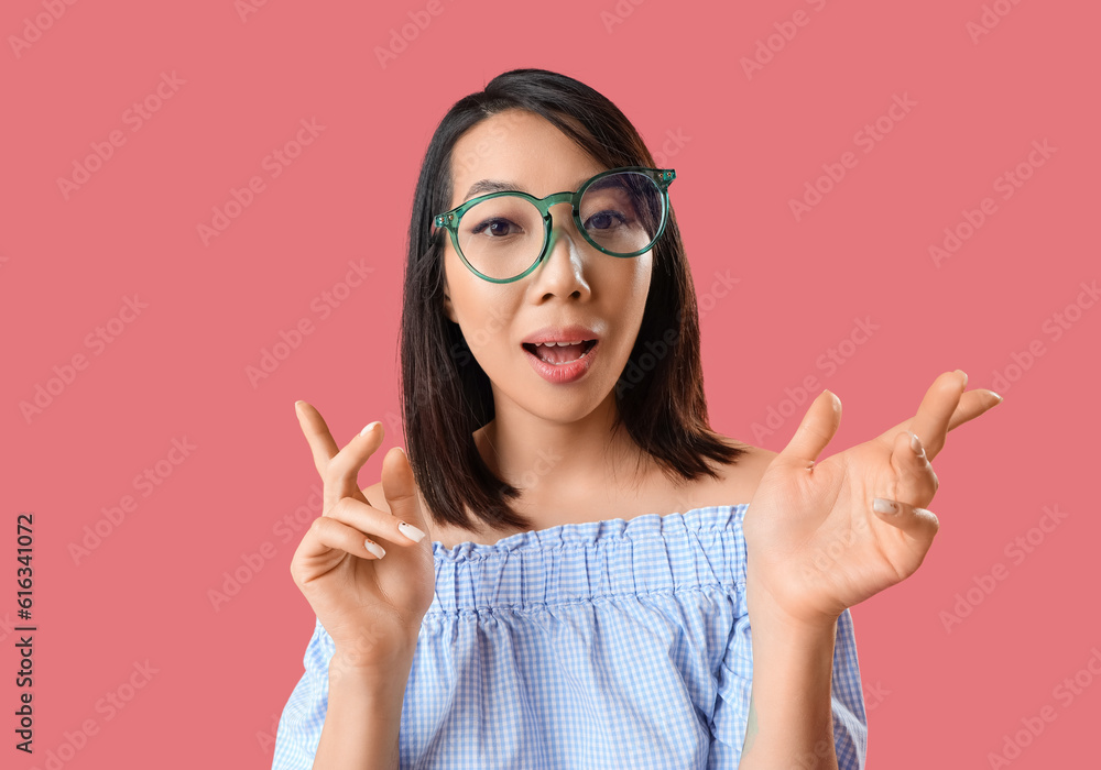 Beautiful Asian woman in stylish eyeglasses on pink background