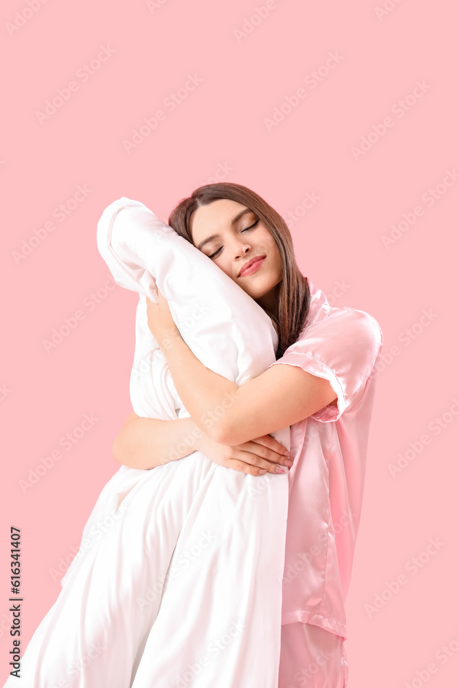 Young woman with soft blanket on pink background