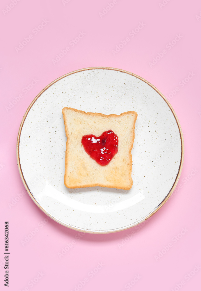 Plate with toast and sweet jam on pink background