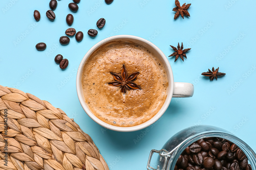 Cup of hot espresso and coffee beans on blue background