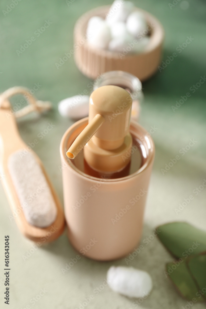 Bottle of cosmetic product and massage brush on color background, closeup