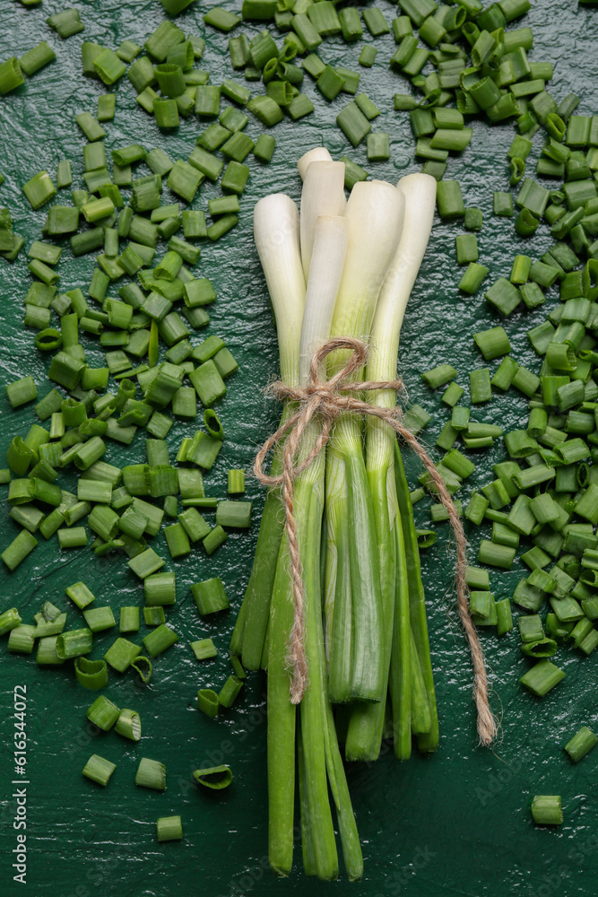 Fresh green onion and slices on color background