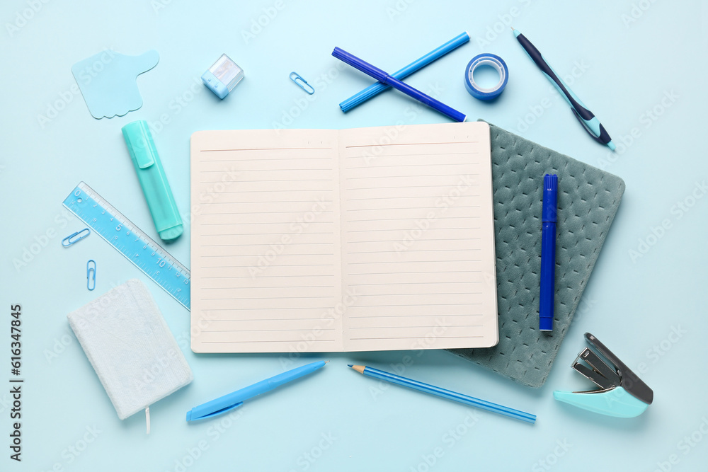 Notebooks with different stationery on blue background