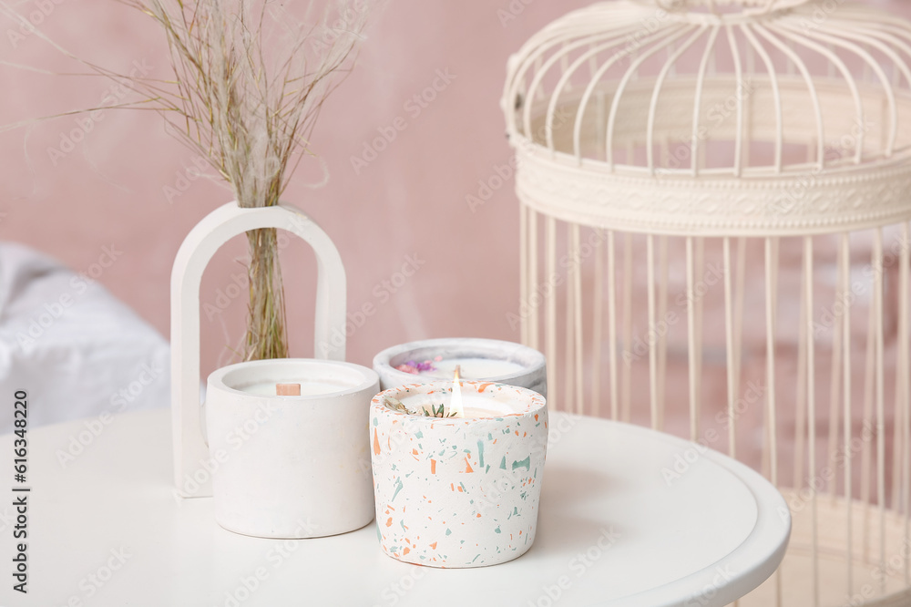 Holders with candles on table in light room, closeup