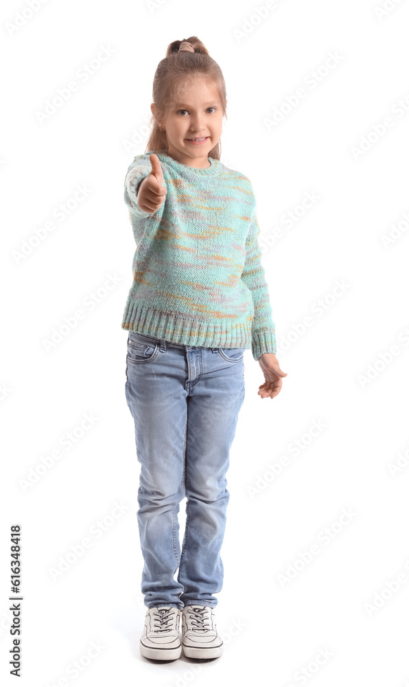 Cute little girl in knitted sweater showing thumb-up on white background