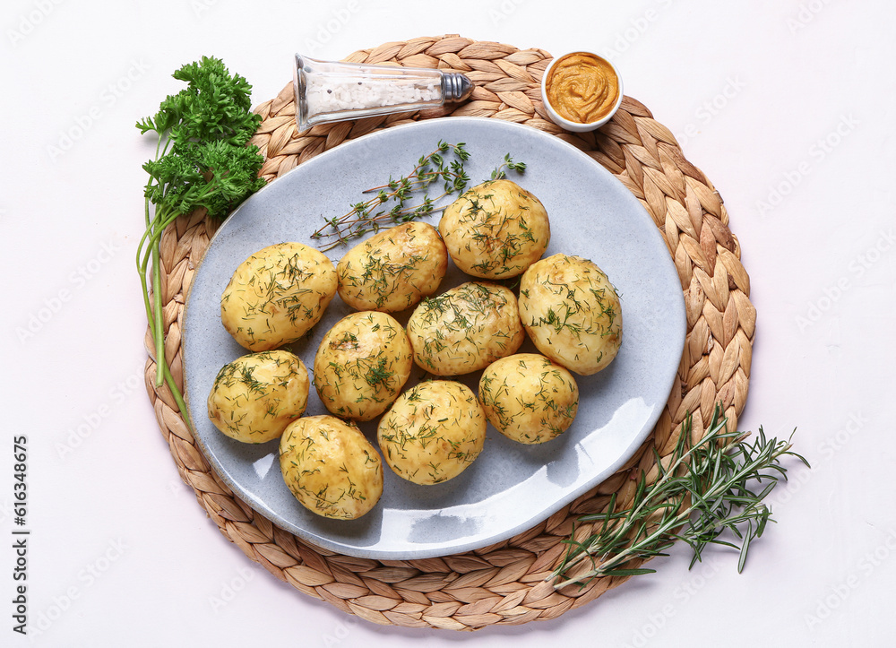 Plate of boiled baby potatoes with dill and parsley on white background