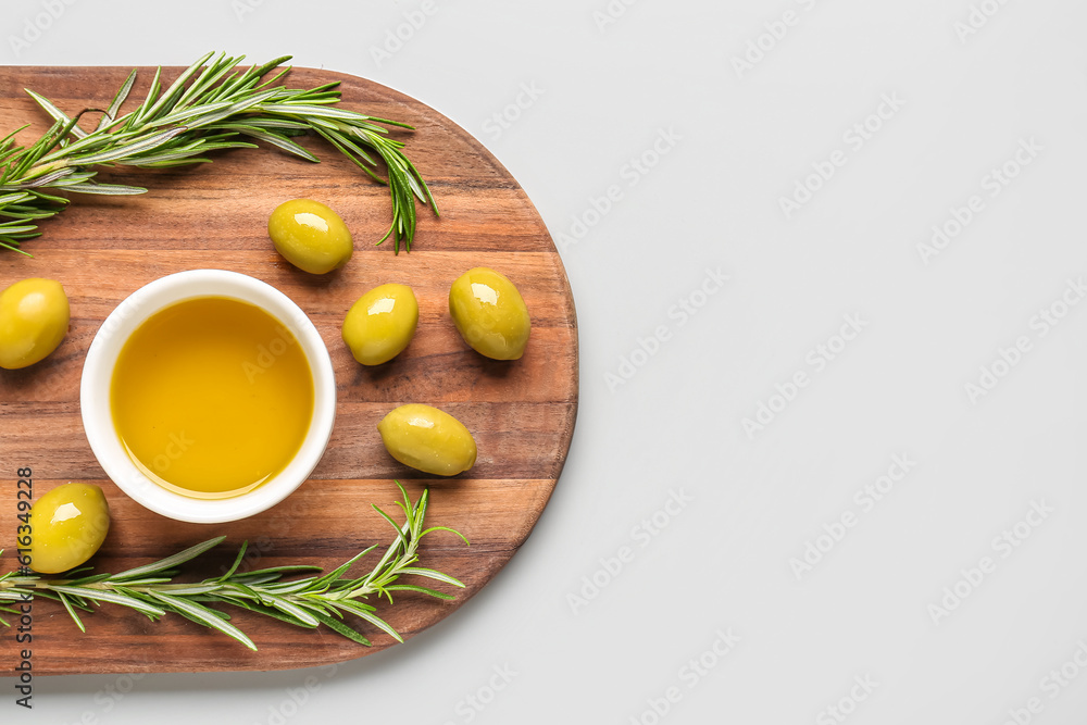 Bowl with fresh olive oil on grey background