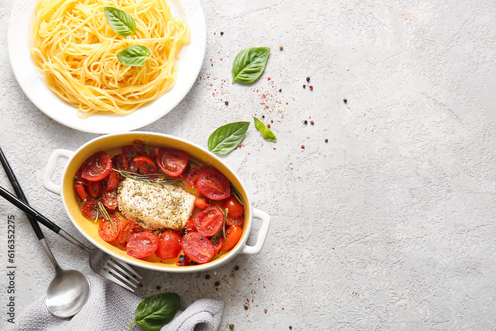 Baking dish with tasty tomatoes, feta cheese and pasta on grey background