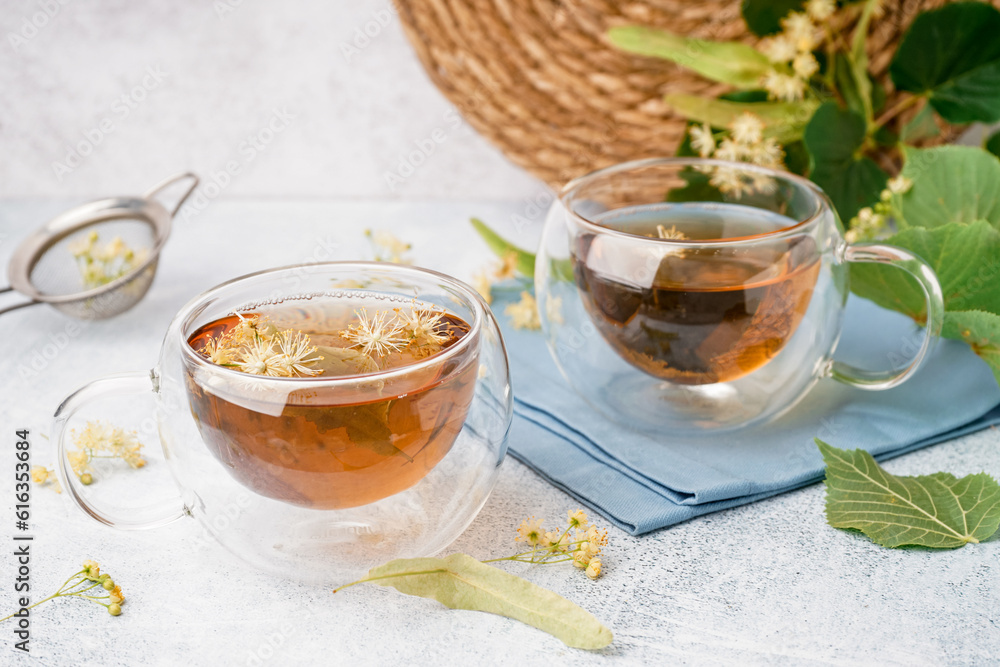 Glass cup of linden tea on white background