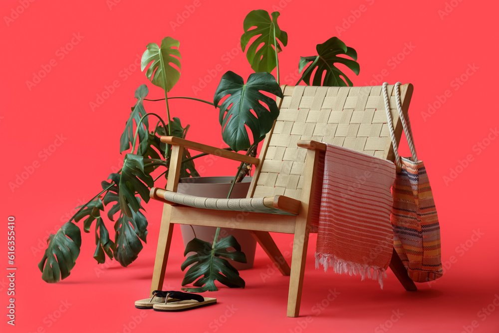 Composition with chair, plant and beach accessories on red background. Summer vacation concept