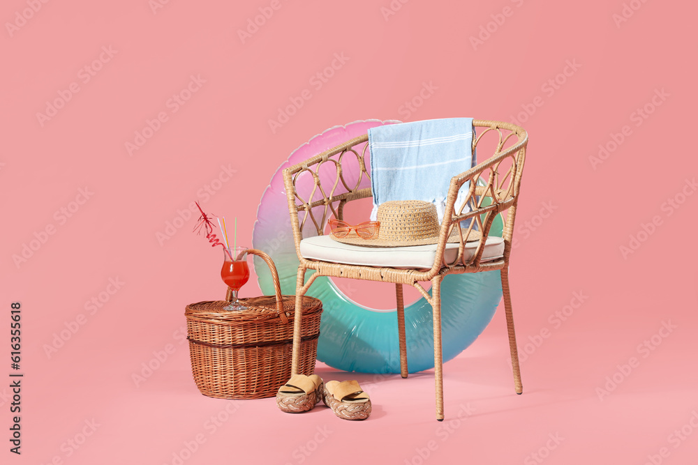 Composition with chair, wicker basket, beach accessories and cocktail on pink background. Travel con