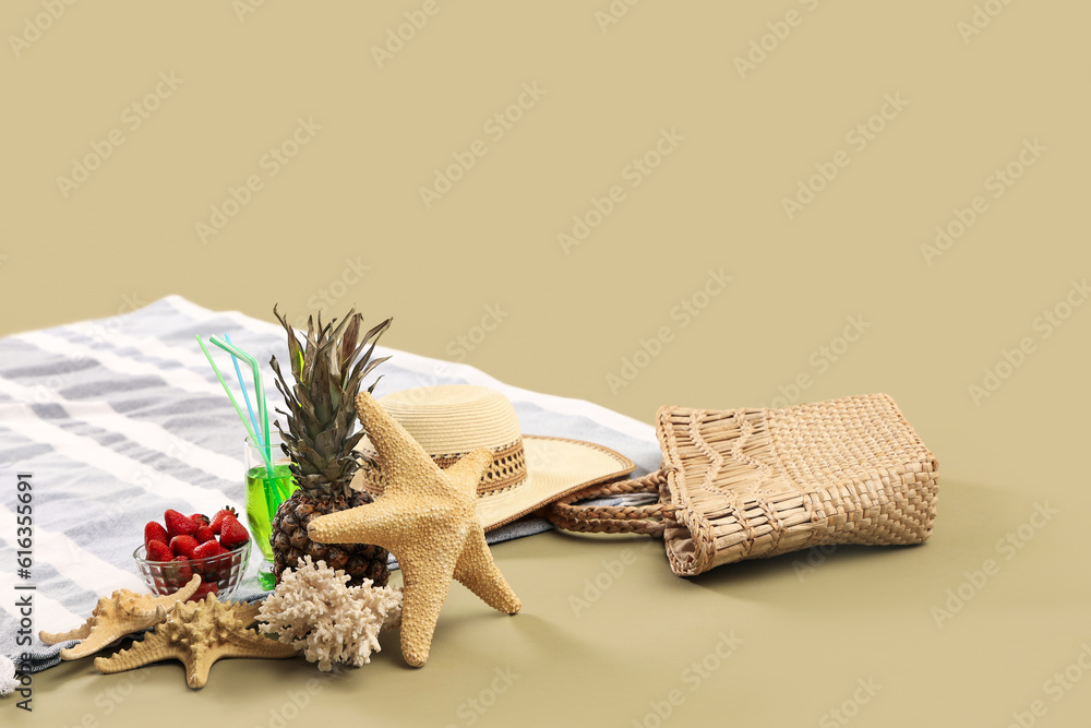 Beach blanket with fruits, cocktail and beach accessories on green background. Travel concept