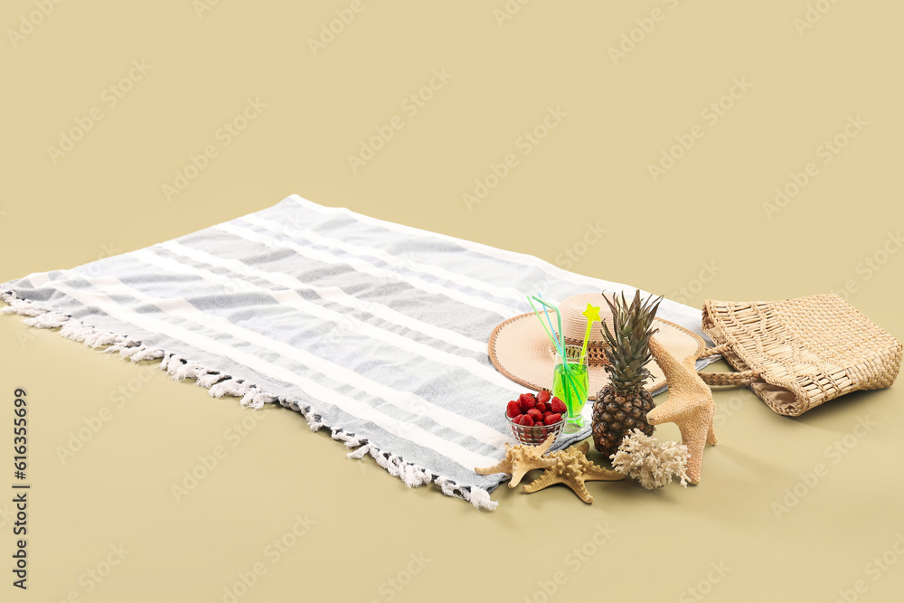 Beach blanket with fruits, cocktail and beach accessories on green background. Travel concept