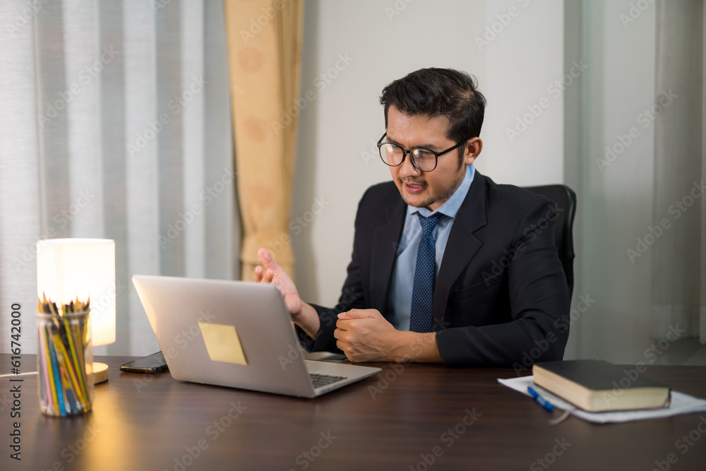 Asian handsome businessman sitting and discussing Discuss while meeting online with your laptop from