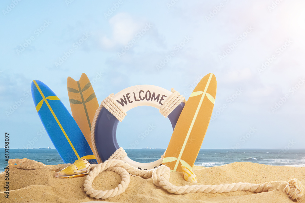 Surfboards, lifebuoy and rope on beach sand