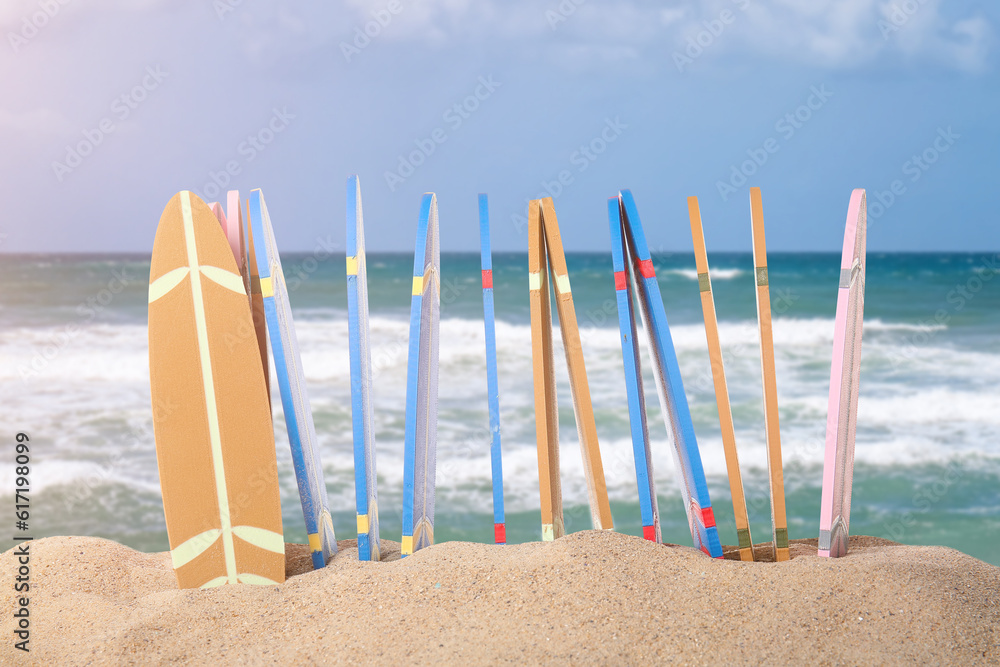 Different surfboards on beach sand