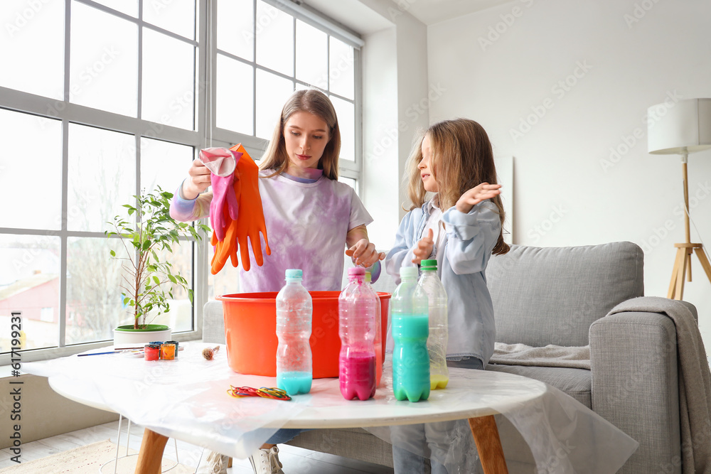 Little girl with her sister making tie-dye t-shirt at home