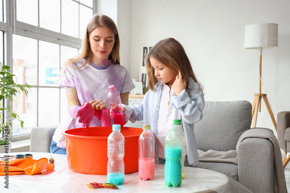 Little girl with her sister making tie-dye t-shirt at home