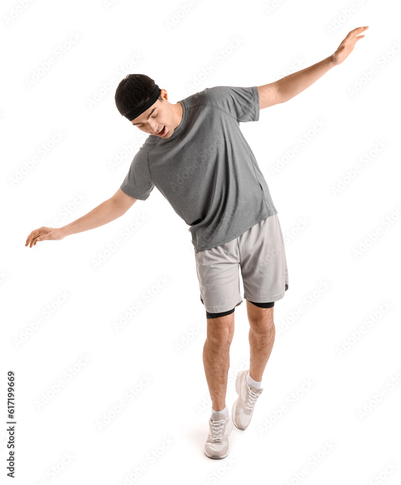 Sporty young man balancing on white background