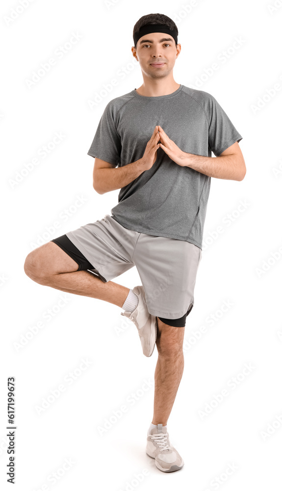 Sporty young man meditating on white background. Balance concept