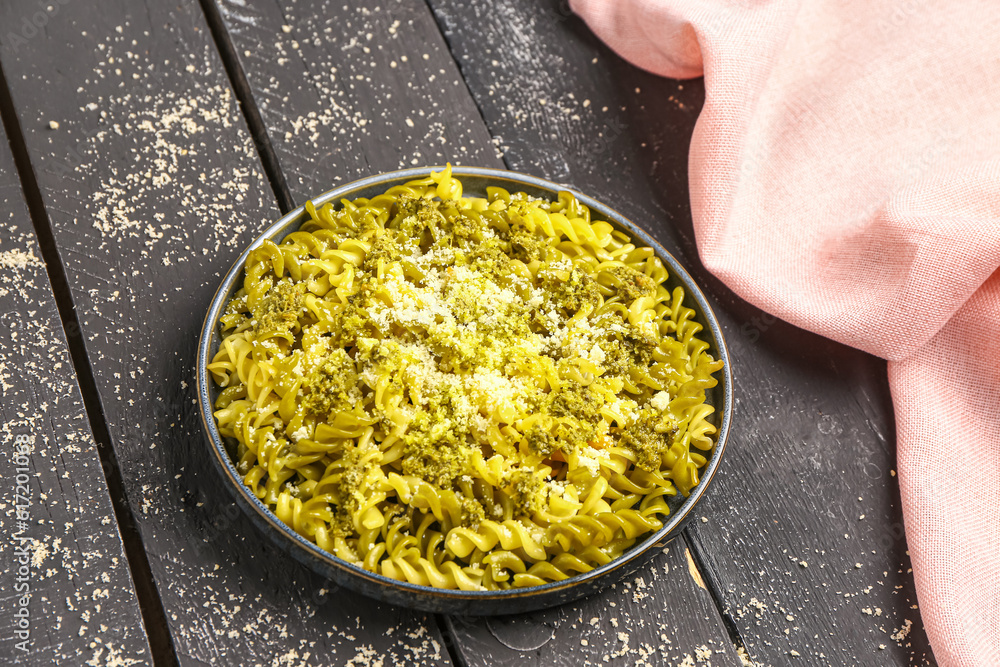 Plate of tasty Italian pasta with Parmesan cheese on dark wooden background