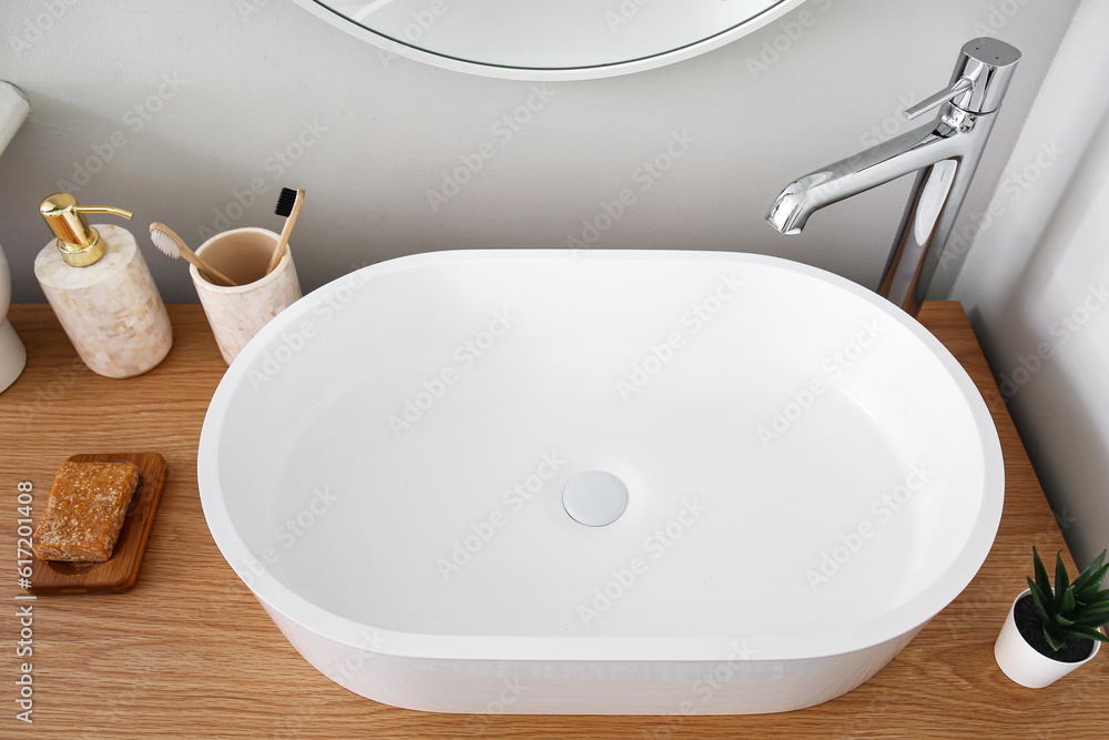 White sink with bath accessories on table in room