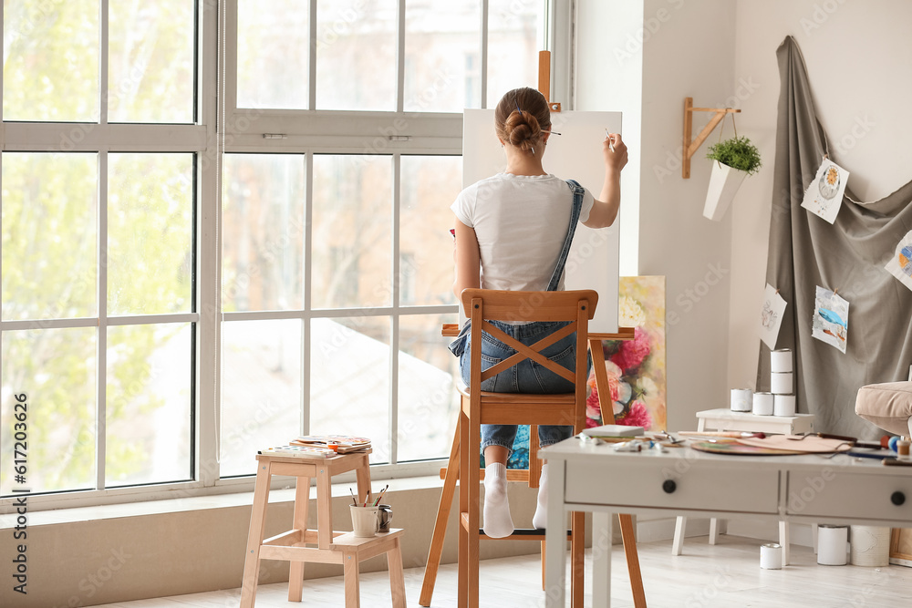 Female artist painting picture in  workshop