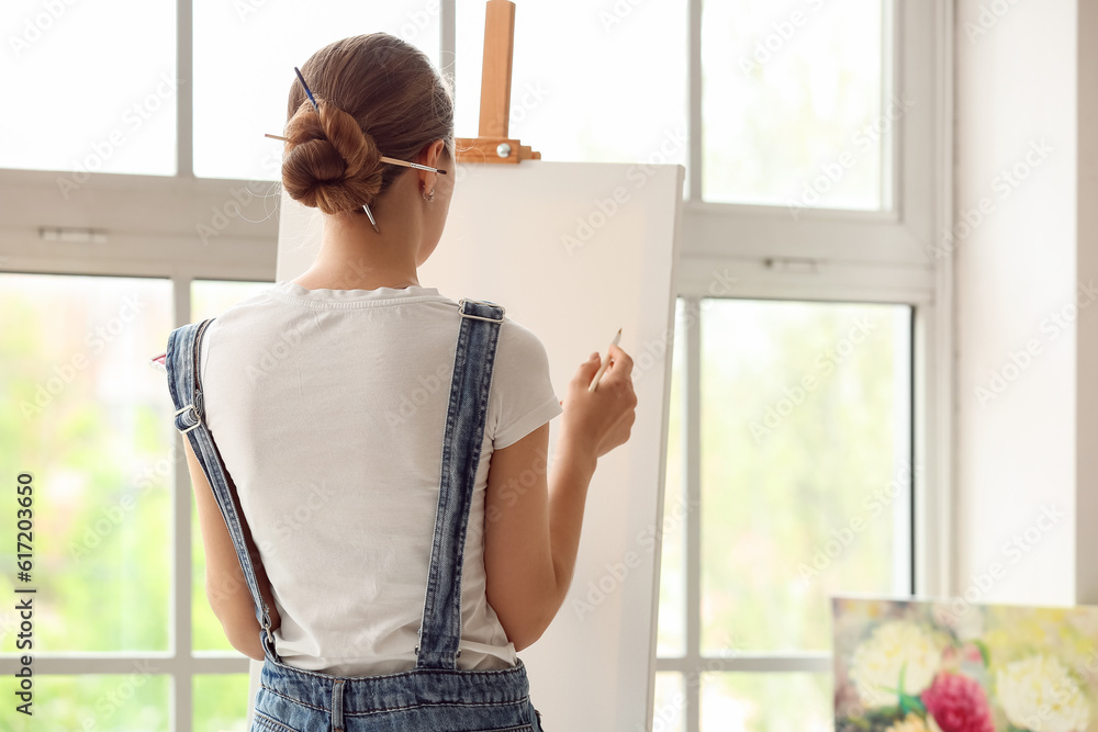 Female artist painting picture in  workshop