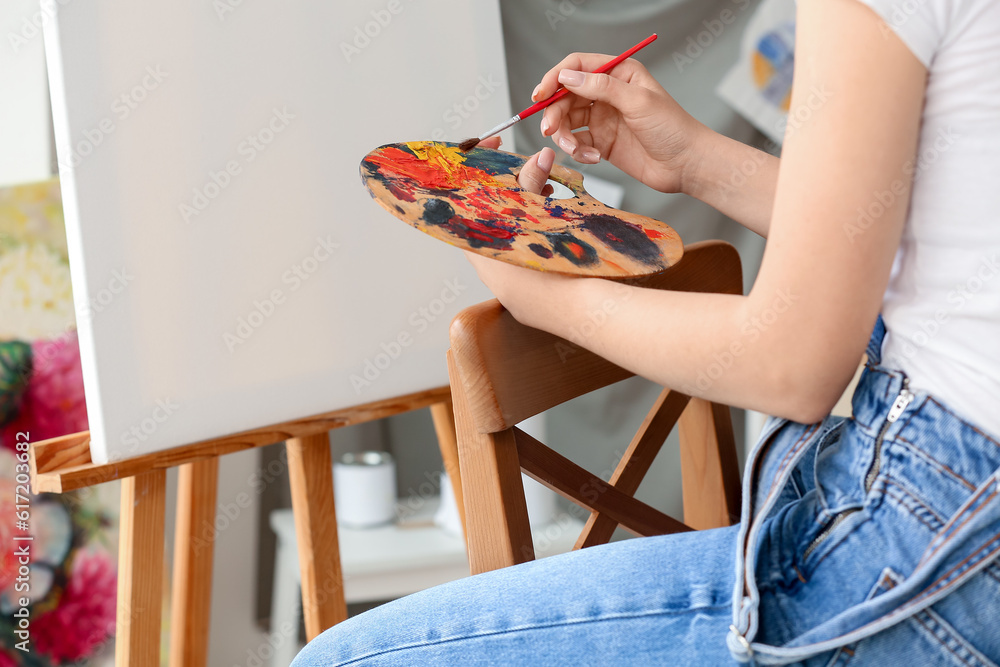 Female artist painting picture in  workshop