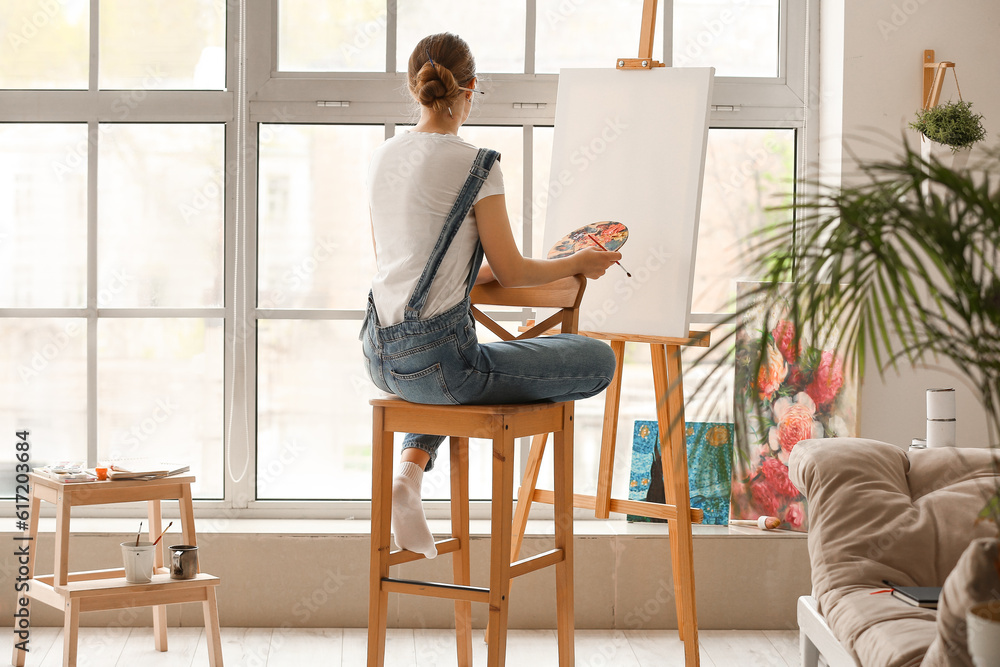 Female artist painting picture in  workshop