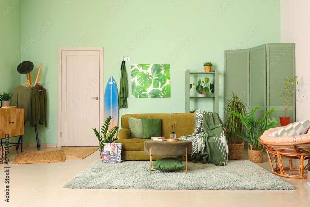 Interior of stylish living room with surfboard, sofa and armchair