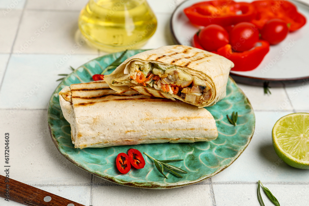 Plates with tasty shawarma with pepper on white tile table