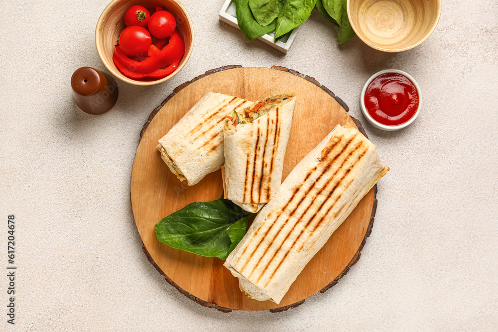 Board of tasty shawarma and bowl with tomatoes on white table