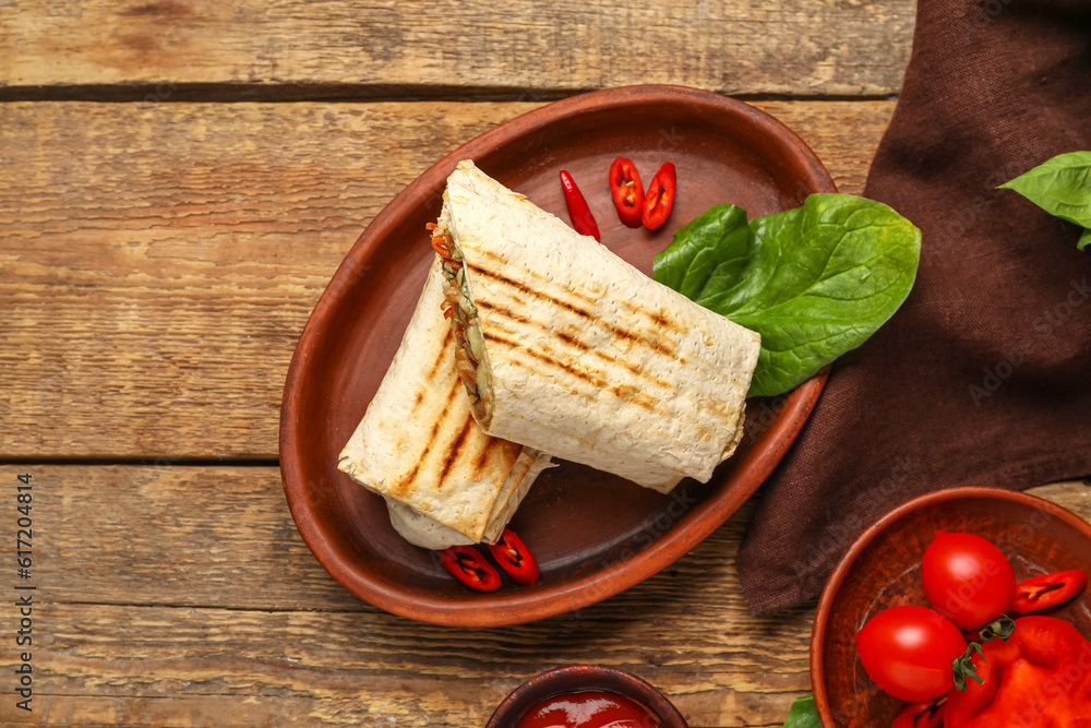 Plate with tasty shawarma on wooden background