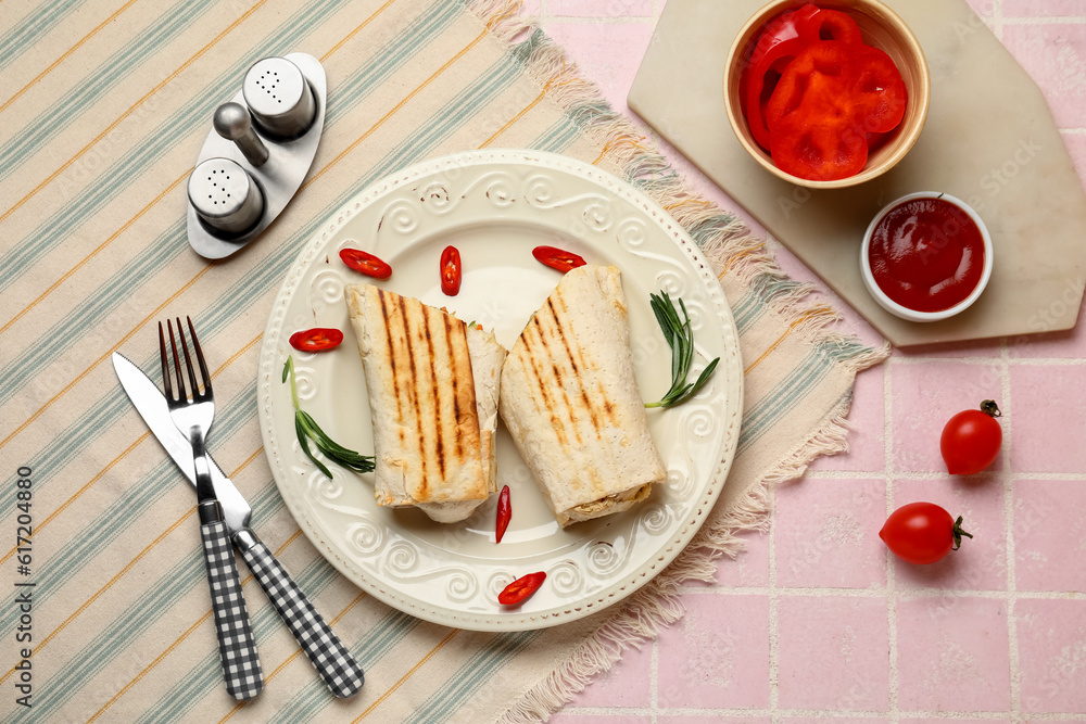 Plate with tasty shawarma and chilli on pink tile table