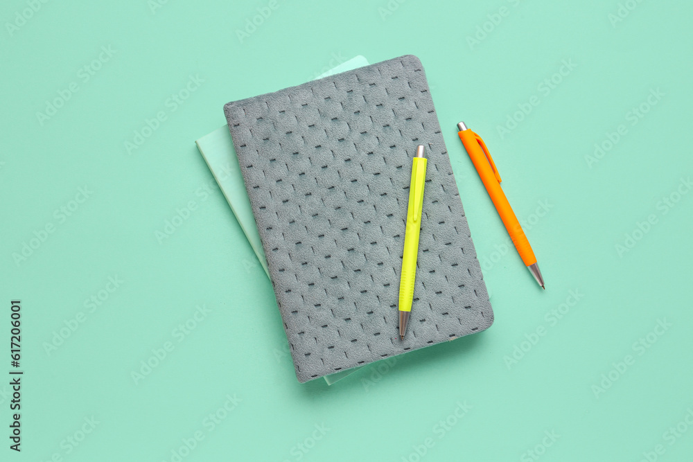 Notebooks with pens on color background