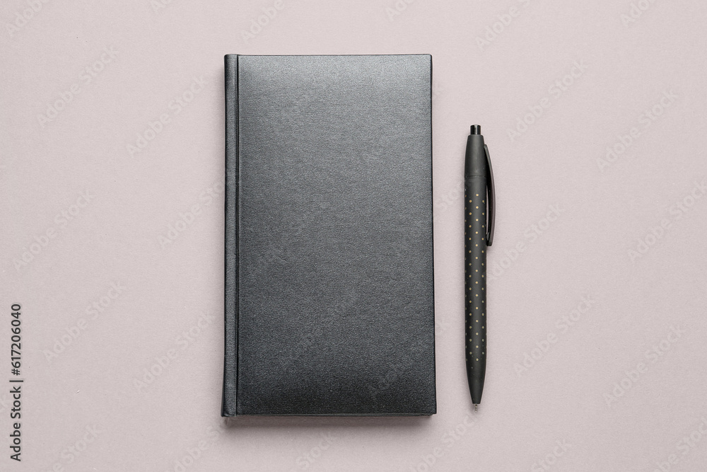 Blank notebook and pen on grey background