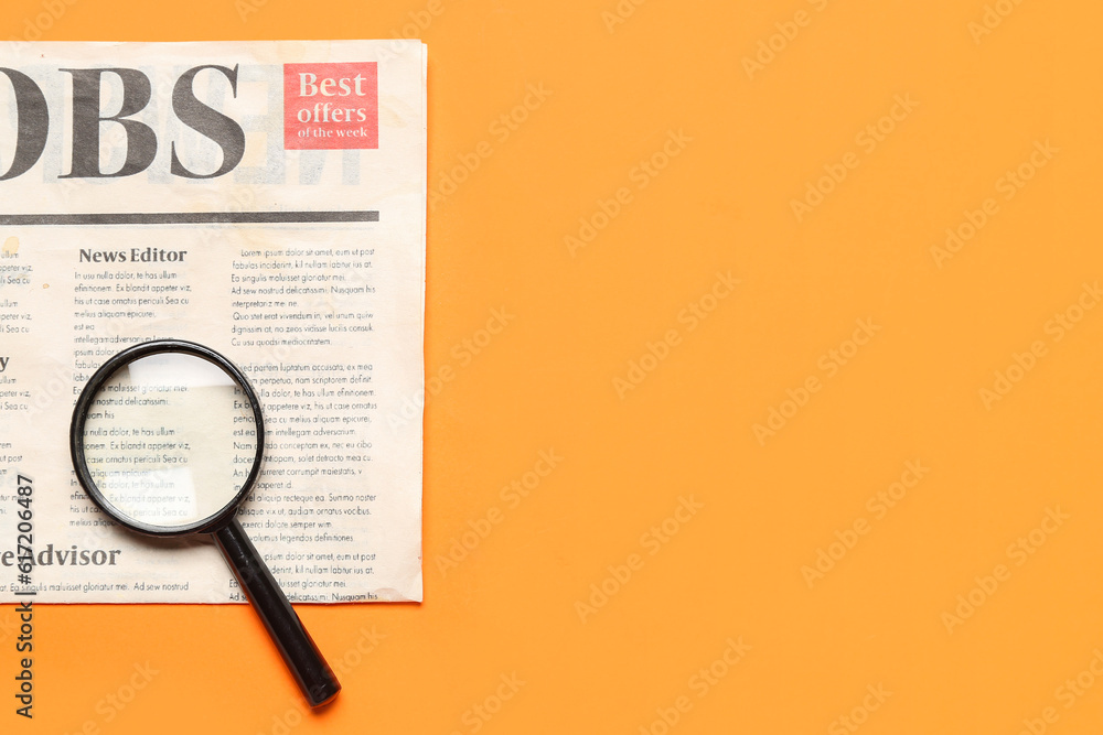 Mini magnifier and newspaper with headline JOBS on orange background. Search concept