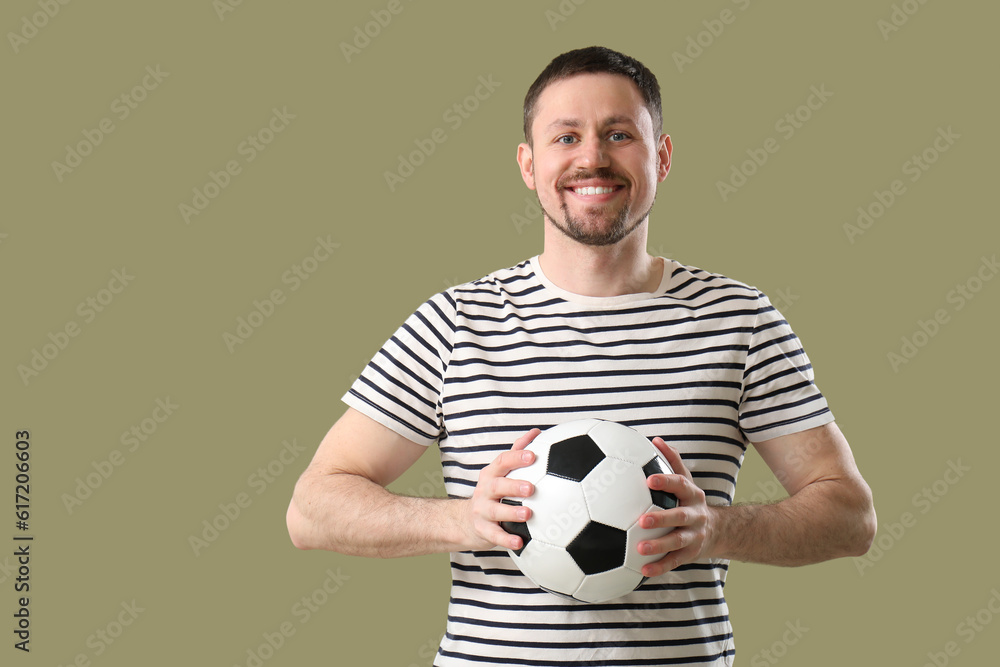 Happy man with soccer ball on color background